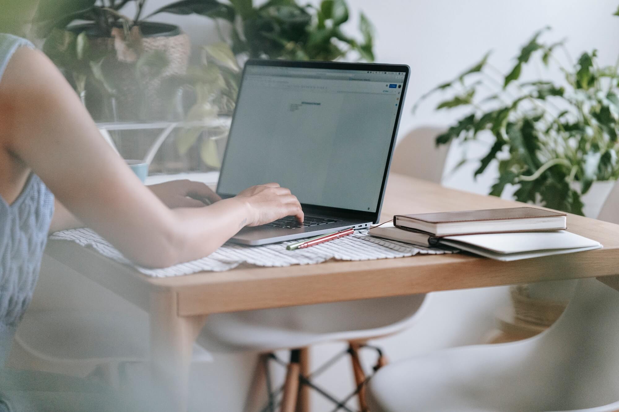 A woman sitting at a desk using a word processor on her computer to add commas to a title