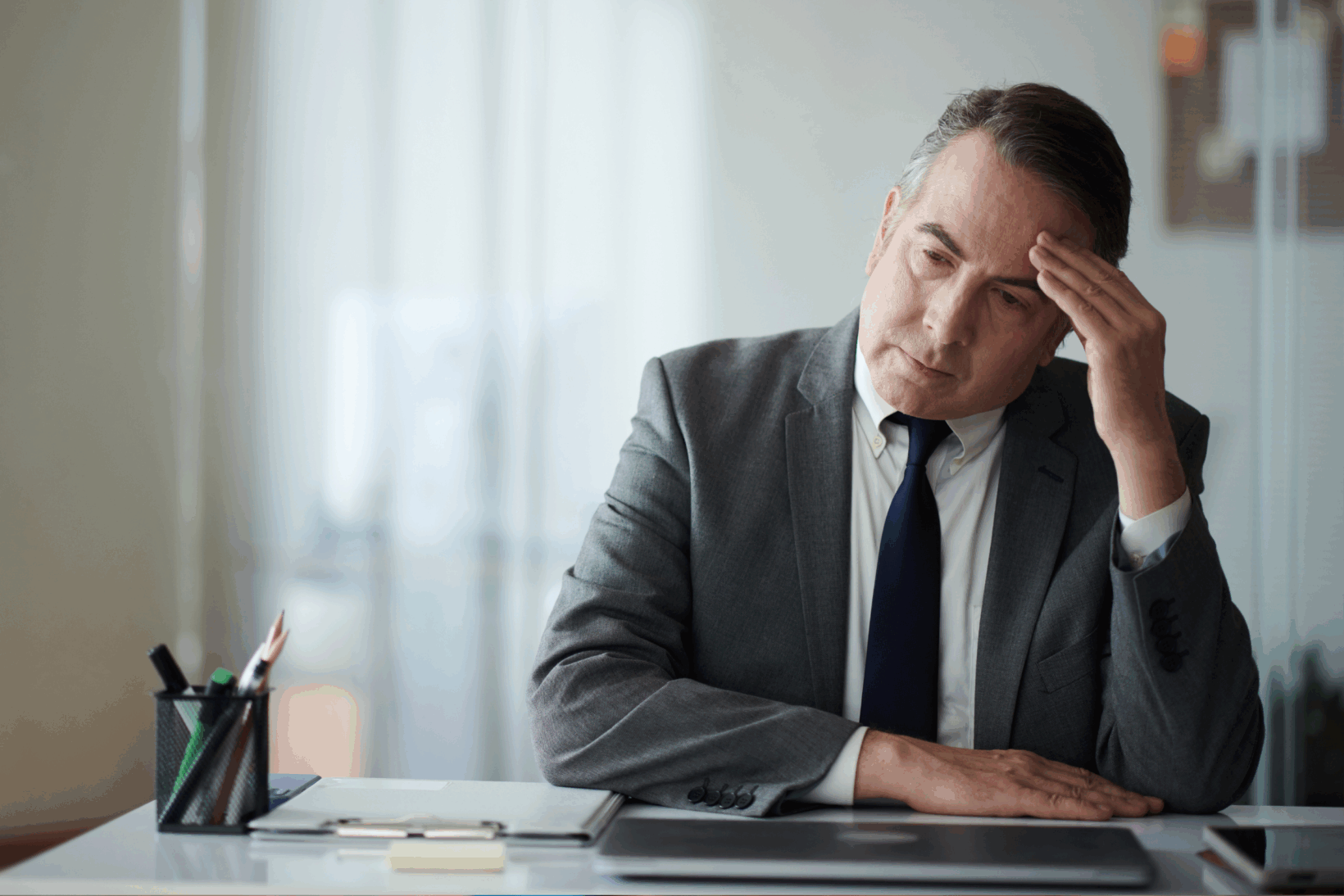 A middle-aged concerned attorney sitting at this desk