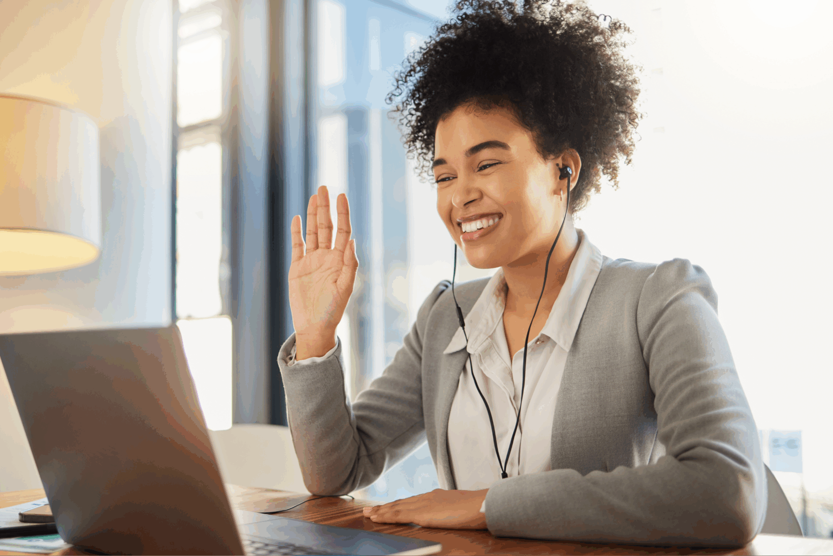 An jubilant attorney greeting people on her laptop during a Zoom call