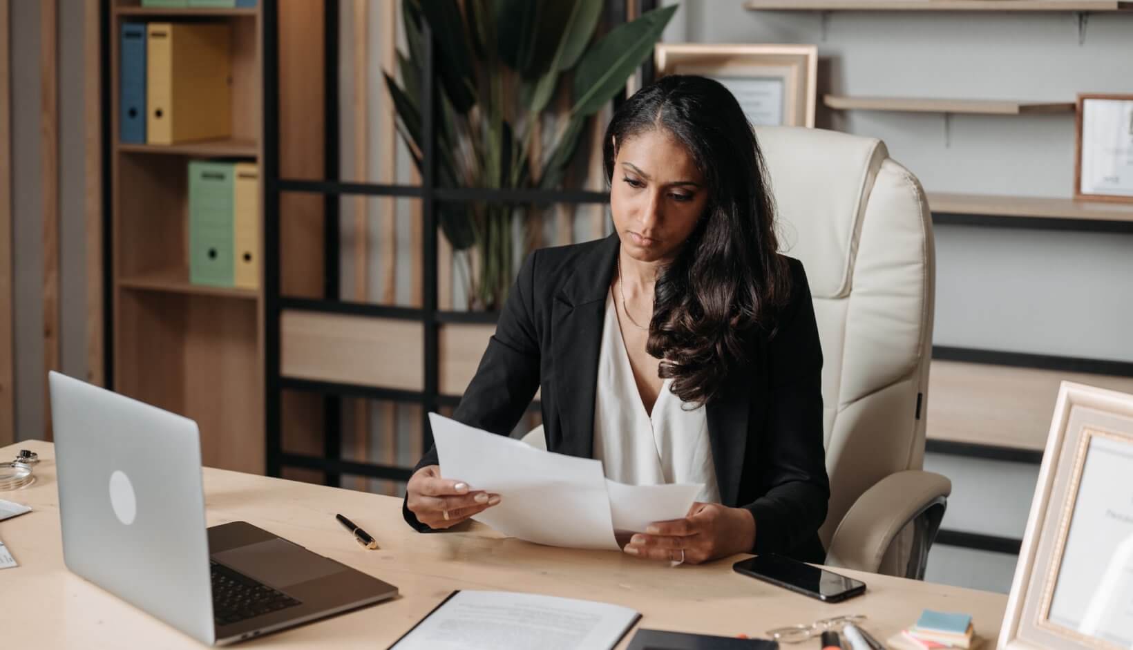 A lawyer working at her desk as she reads a printed page to check if the metadata was removed