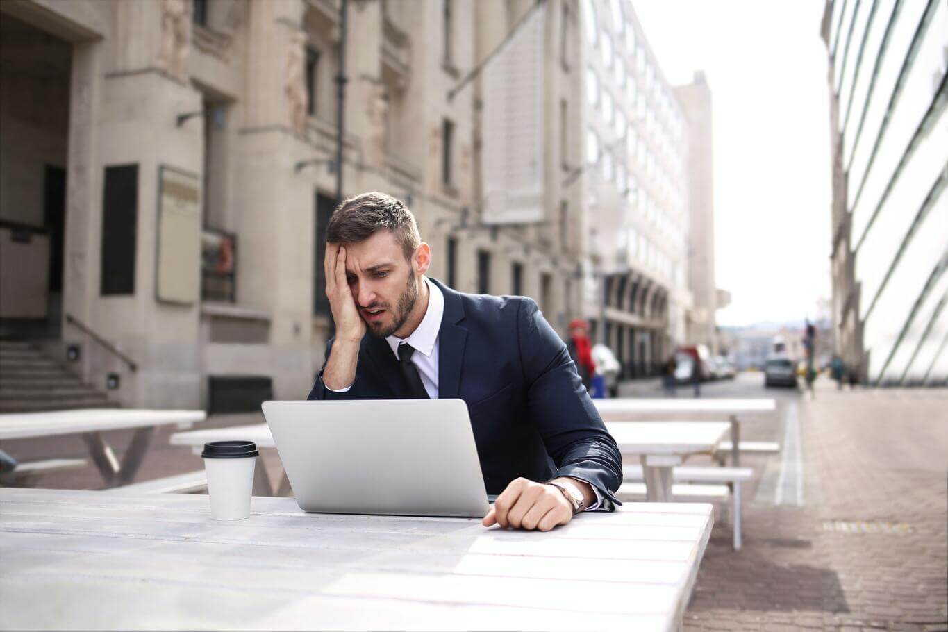 A disappointed lawyer using his laptop outside