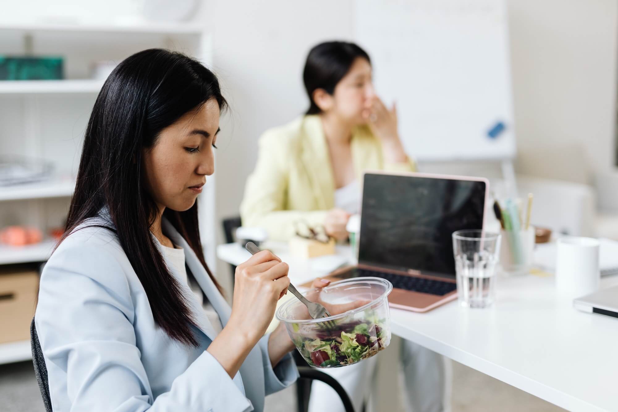 A lawyer eating a healthy salad during her lunch break