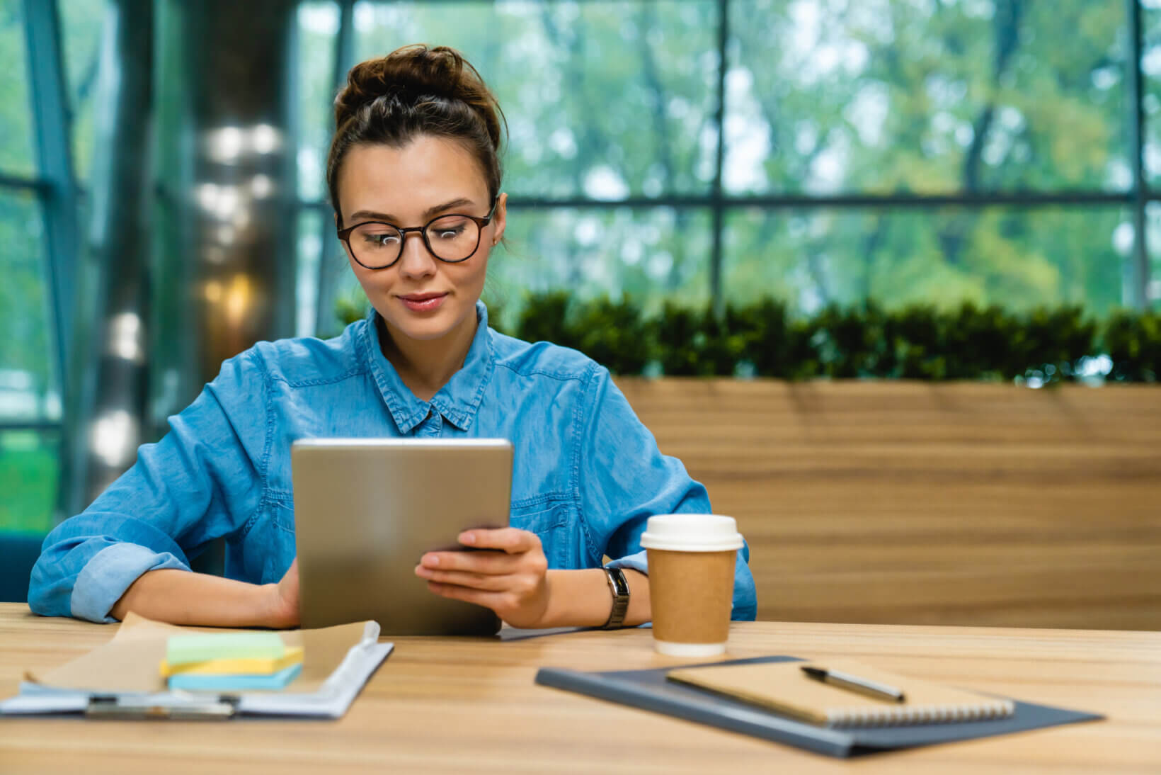 Young lawyer sitting at a table using a tablet to access Texas Bar Practice's online subscriptions