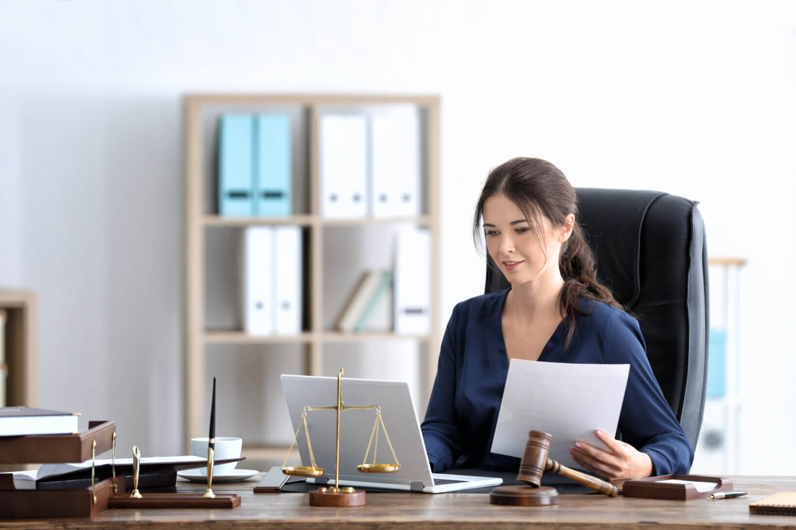 A young female sole practitioner sitting at her desk working on an upcoming case.