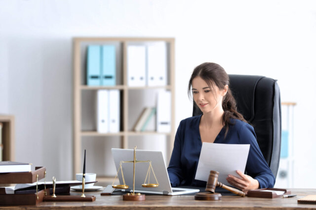 A young female sole practitioner sitting at her desk working on an upcoming case.