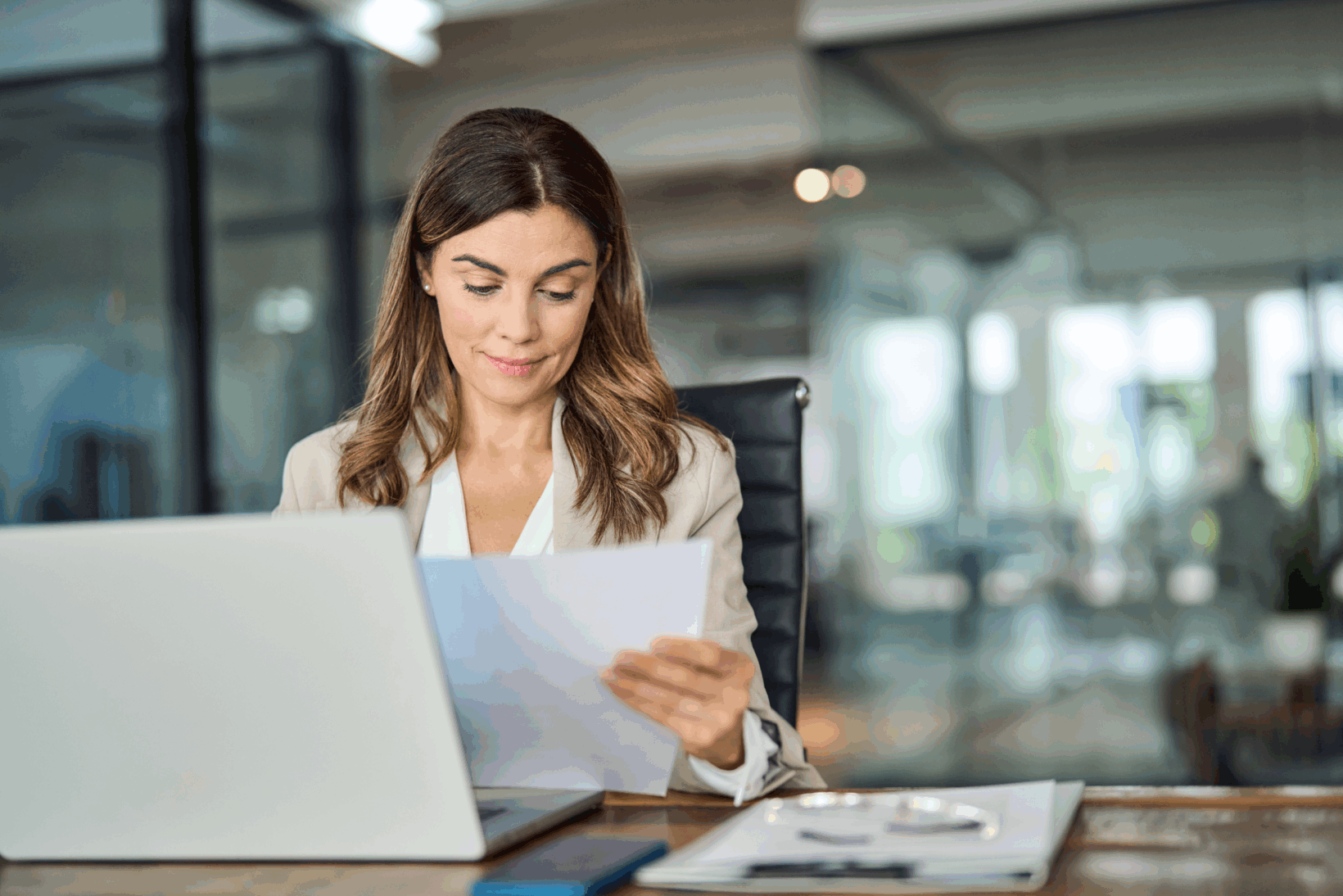 A sole practitioner looking at a piece of paper at her desk