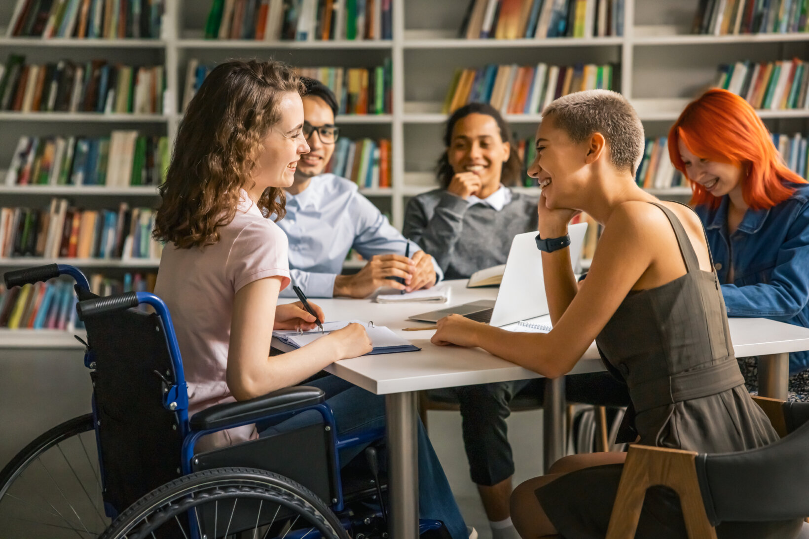 Young law student with disability cooperating on project with college friends