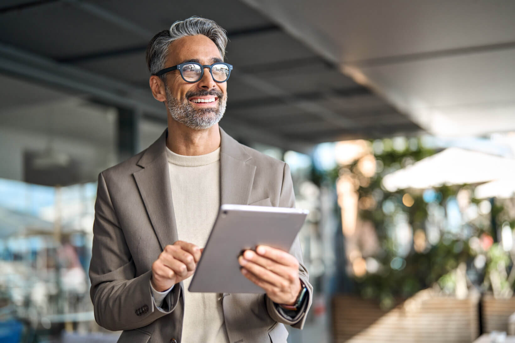 Happy middle aged professional business man executive manager using tablet.