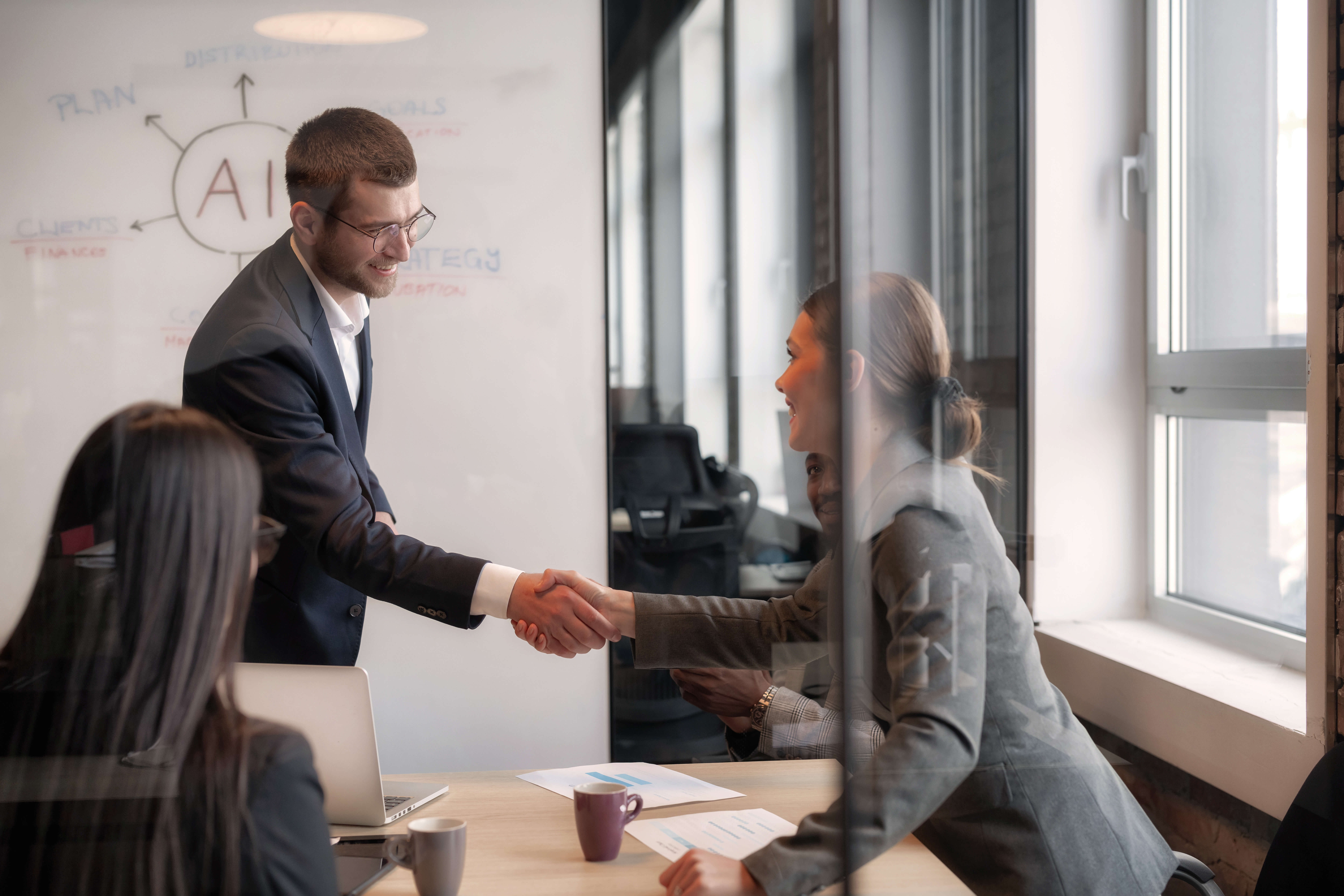 Shaking hands during a meeting about AI